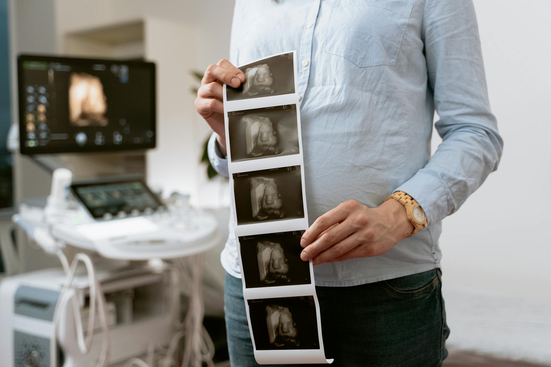 photo of woman holding the printed image of her baby